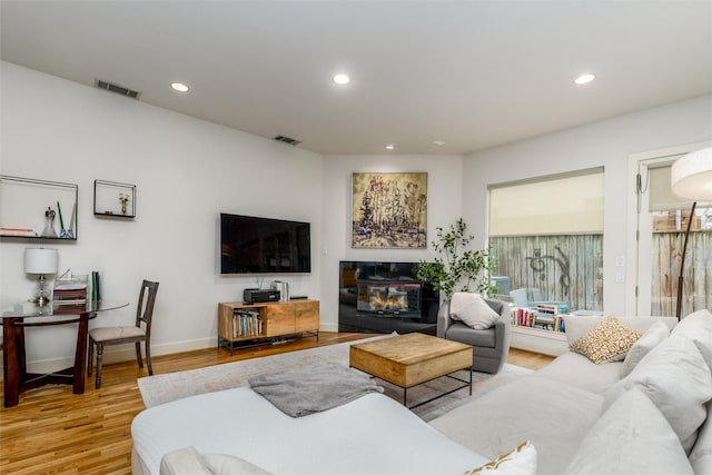 living area with visible vents, wood finished floors, and recessed lighting