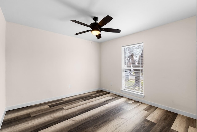 unfurnished room featuring ceiling fan, wood finished floors, and baseboards