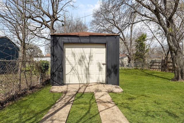 view of outdoor structure with driveway, an outdoor structure, and fence