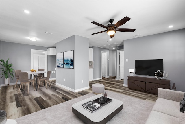 living room with recessed lighting, baseboards, and wood finished floors