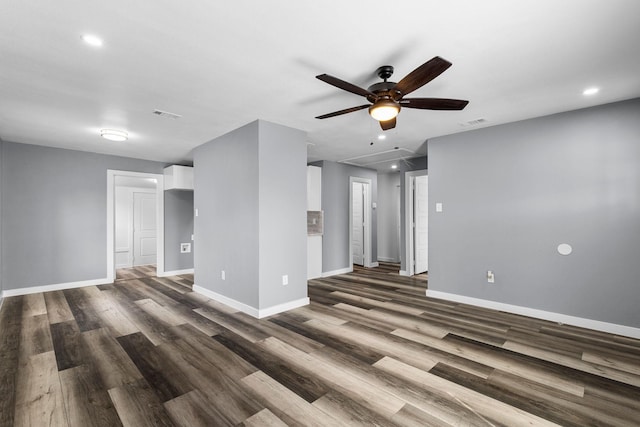 empty room with dark wood-style floors, visible vents, baseboards, and a ceiling fan