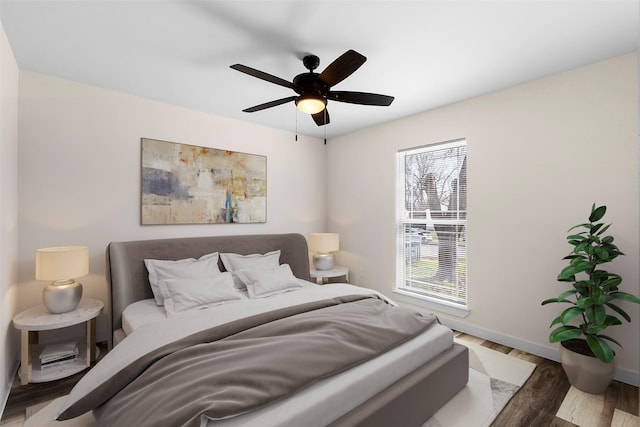 bedroom featuring wood finished floors, a ceiling fan, and baseboards