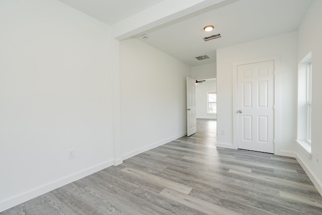 unfurnished room featuring visible vents, baseboards, and wood finished floors