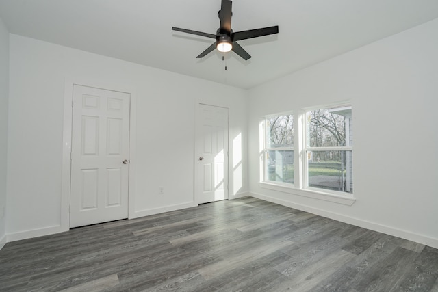 unfurnished bedroom with dark wood-style floors, baseboards, and a ceiling fan