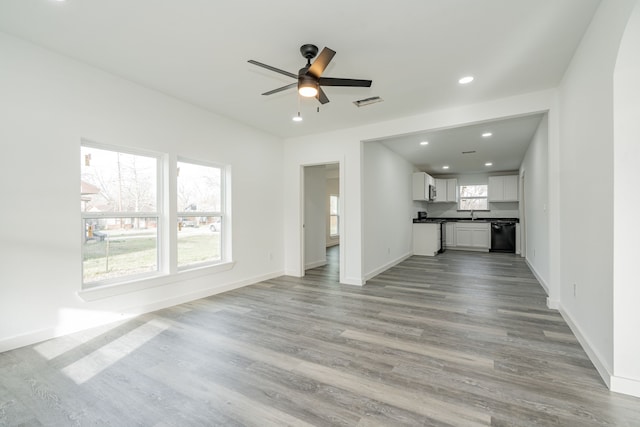 unfurnished living room featuring recessed lighting, visible vents, light wood-style floors, a ceiling fan, and baseboards