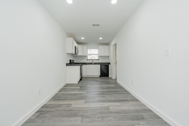 kitchen with black dishwasher, baseboards, visible vents, gas range oven, and a sink