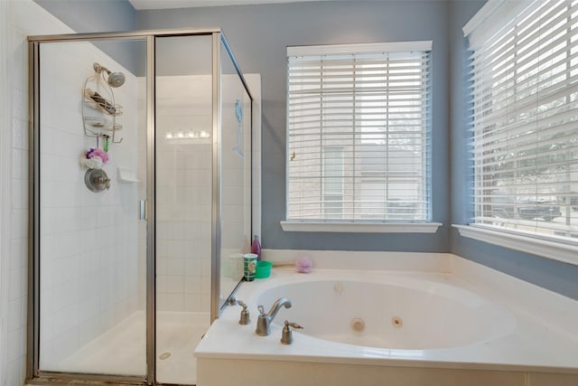 full bathroom with a shower stall, a tub with jets, and a wealth of natural light