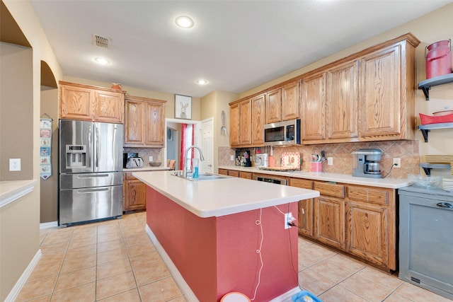 kitchen with light tile patterned floors, stainless steel appliances, a sink, and visible vents