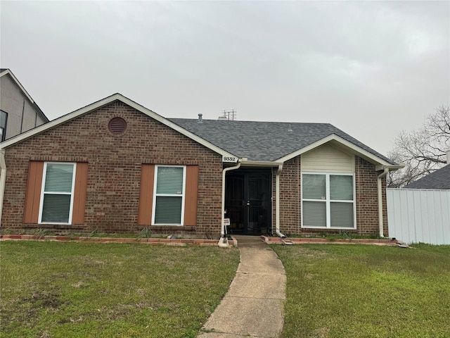 single story home with brick siding, a front lawn, and a shingled roof