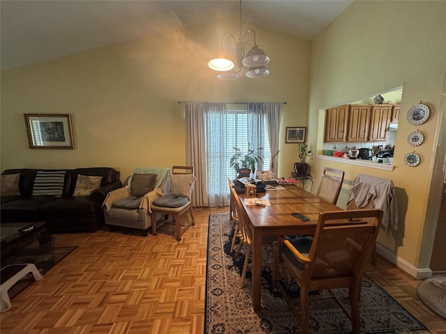 dining space featuring high vaulted ceiling, baseboards, and a chandelier