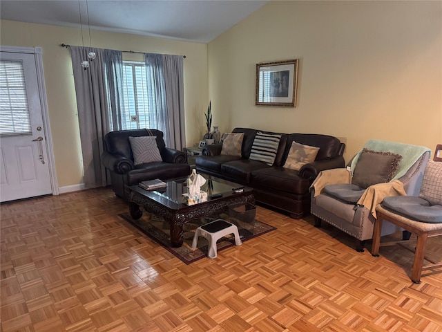 living room featuring a healthy amount of sunlight, baseboards, and vaulted ceiling