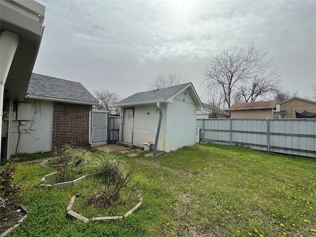 view of yard featuring a storage unit, fence, and an outbuilding