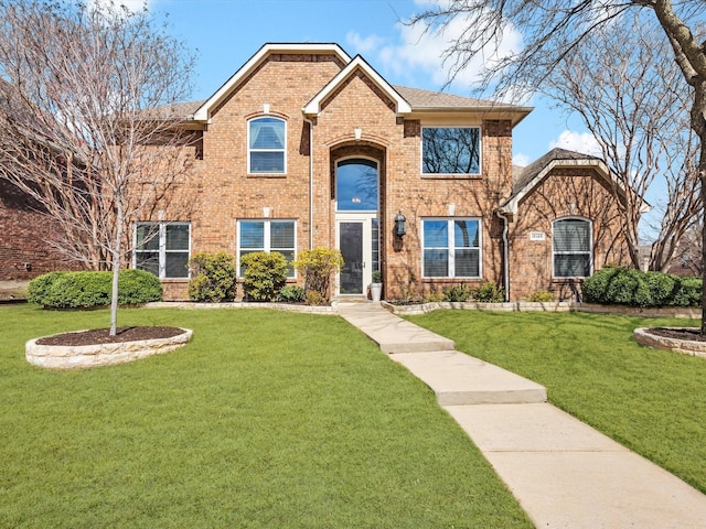 view of front facade with a front lawn, brick siding, and roof with shingles