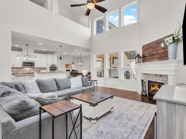 living room featuring baseboards, recessed lighting, a fireplace, dark wood-style flooring, and ceiling fan