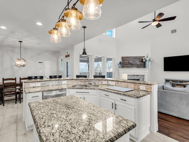 kitchen with visible vents, a large island, ceiling fan with notable chandelier, a sink, and open floor plan