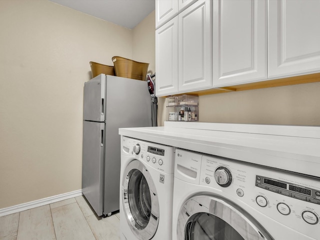 clothes washing area featuring light wood-style floors, cabinet space, baseboards, and washing machine and clothes dryer