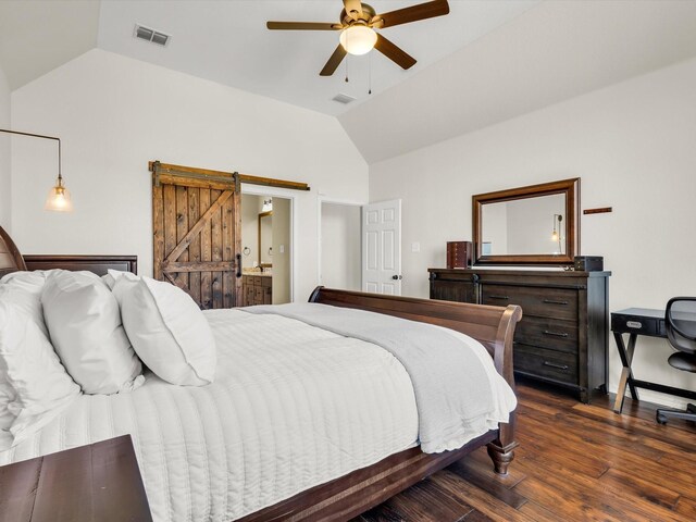 bedroom featuring visible vents, lofted ceiling, dark wood-type flooring, and a barn door