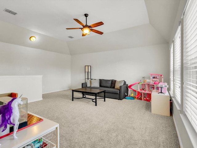 playroom featuring vaulted ceiling, a ceiling fan, visible vents, and carpet floors