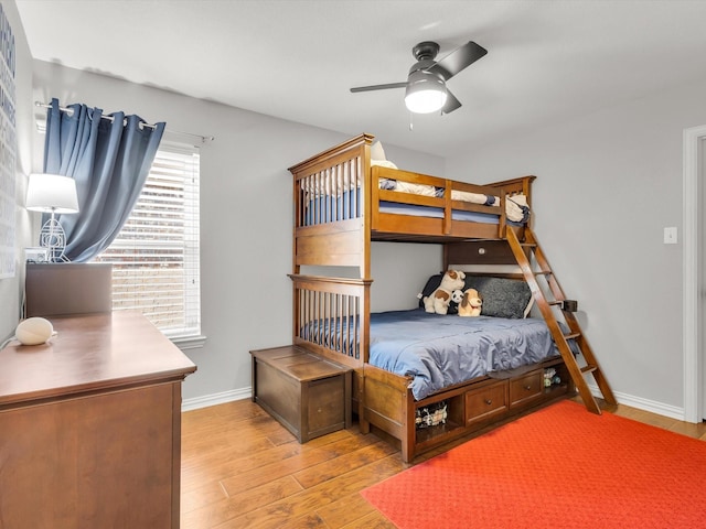 bedroom with ceiling fan, baseboards, and wood finished floors