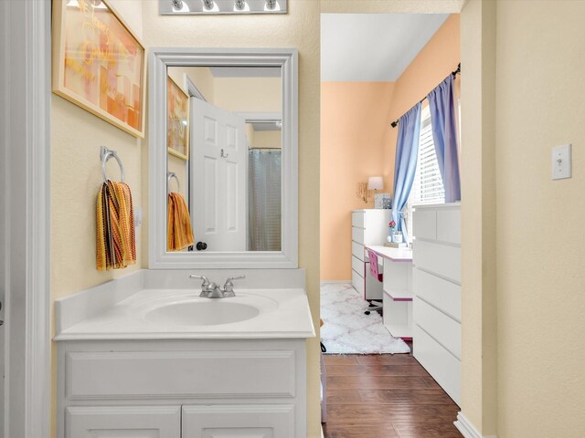 full bathroom featuring wood finished floors and vanity