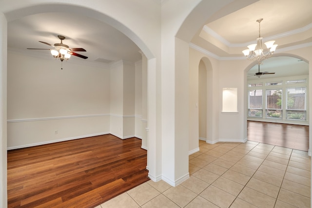 unfurnished room featuring light tile patterned floors, ceiling fan with notable chandelier, crown molding, and baseboards