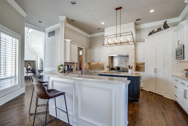 5340 Jessica Ln, Frisco, TX 75034 - kitchen with stainless steel microwave, a peninsula, backsplash, a kitchen bar, and crown molding