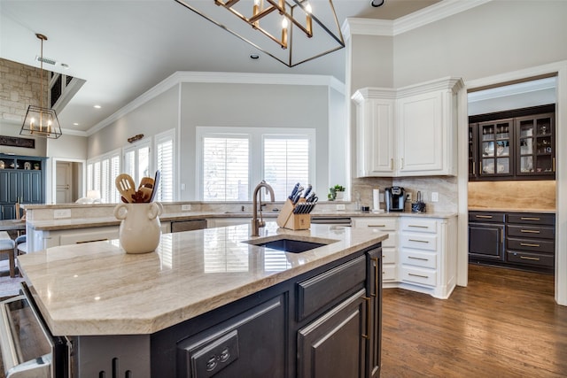 5340 Jessica Ln, Frisco, TX 75034 - kitchen with a kitchen island with sink, white cabinetry, crown molding, light stone counters, and dark wood-style floors