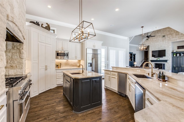 5340 Jessica Ln, Frisco, TX 75034 - kitchen featuring high end appliances, a stone fireplace, open floor plan, a ceiling fan, and white cabinets