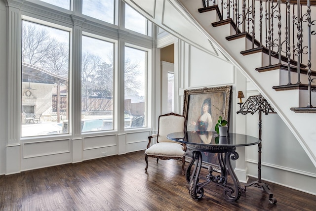 interior space featuring a decorative wall, stairway, and wood finished floors