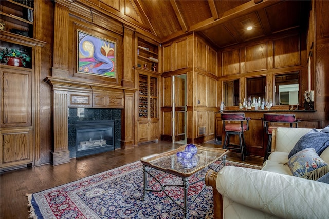 5340 Jessica Ln, Frisco, TX 75034 - living room with built in shelves, wooden walls, a wood ceiling with exposed beams, a fireplace, and dark wood-type flooring
