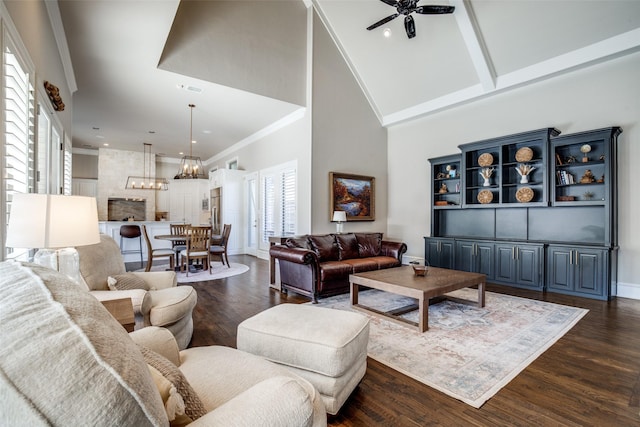 5340 Jessica Ln, Frisco, TX 75034 - living room featuring high vaulted ceiling, a chandelier, a ceiling fan, dark wood-style flooring, and crown molding