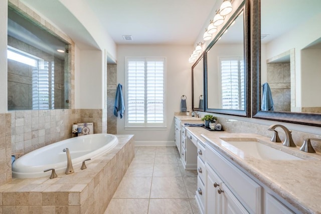 bathroom with a bath, tile patterned flooring, double vanity, and a sink