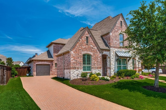 view of front facade with stone siding, brick siding, decorative driveway, and a front yard