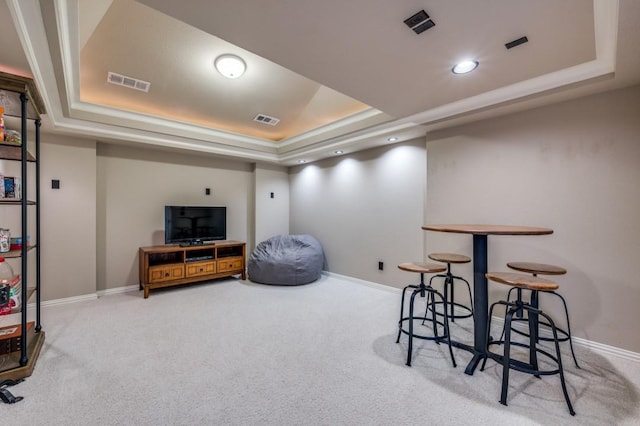 interior space featuring carpet floors, a tray ceiling, and visible vents