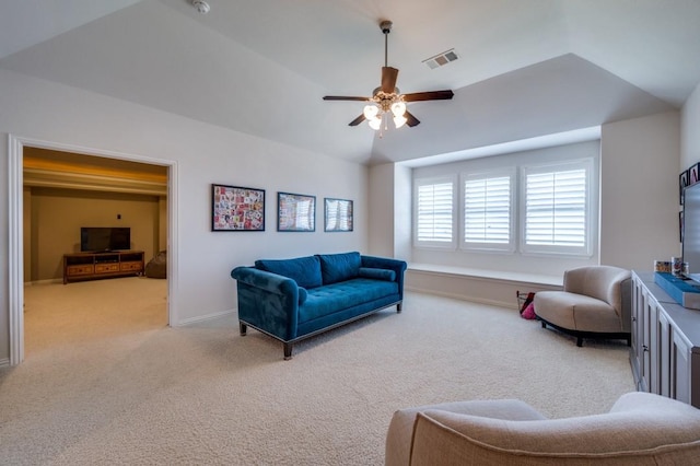 living area featuring lofted ceiling, ceiling fan, carpet floors, visible vents, and baseboards