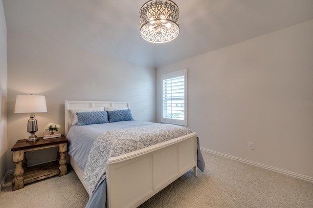 bedroom with a chandelier, carpet, and baseboards