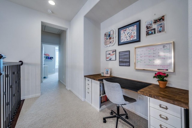 office area with light colored carpet, baseboards, and built in study area