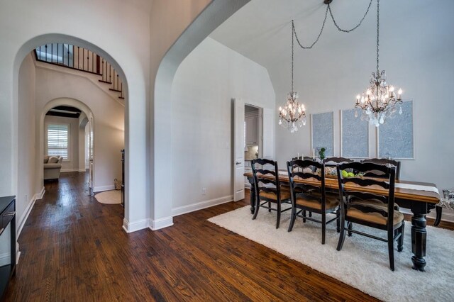 dining area featuring high vaulted ceiling, baseboards, arched walkways, and dark wood-style flooring