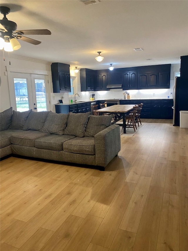 living area with a ceiling fan, light wood-type flooring, and french doors