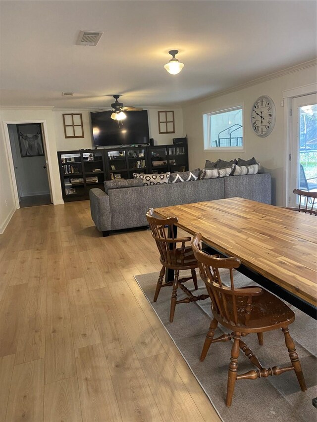 dining space featuring ceiling fan, wood-type flooring, visible vents, and crown molding