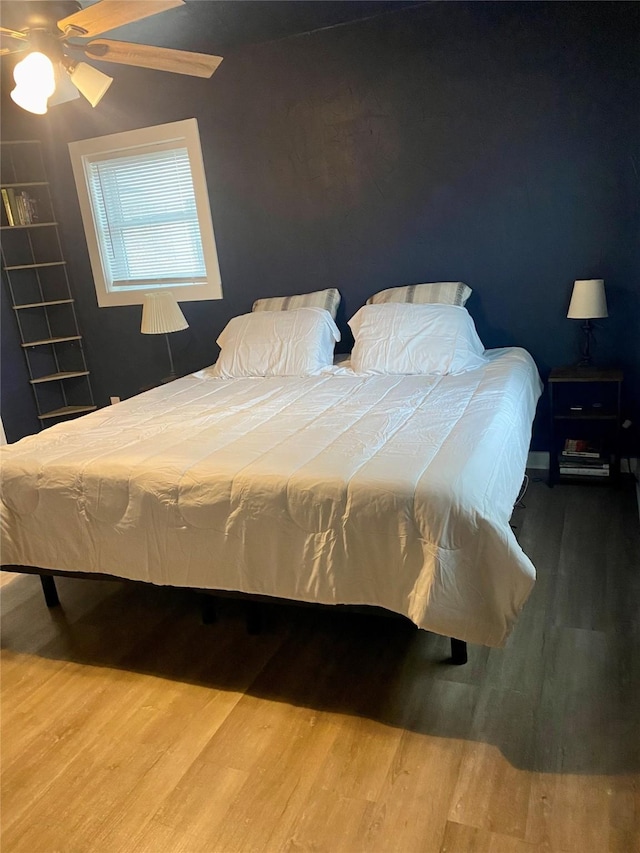 bedroom with a ceiling fan and wood finished floors