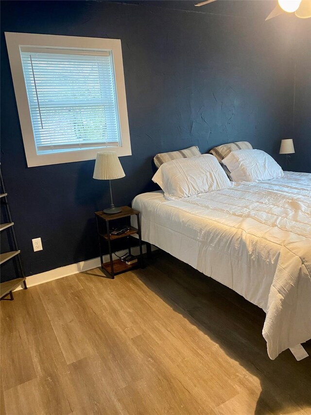 bedroom with wood finished floors and baseboards