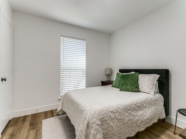 bedroom with baseboards and wood finished floors