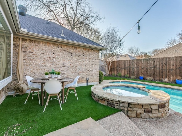 view of swimming pool with an in ground hot tub, a yard, fence, and a fenced in pool