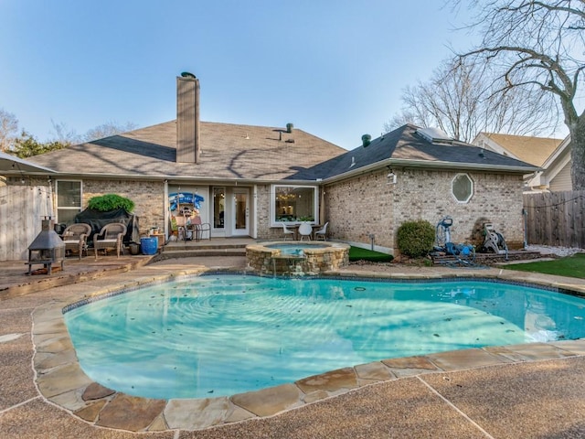 view of pool featuring french doors, a pool with connected hot tub, a patio, and fence