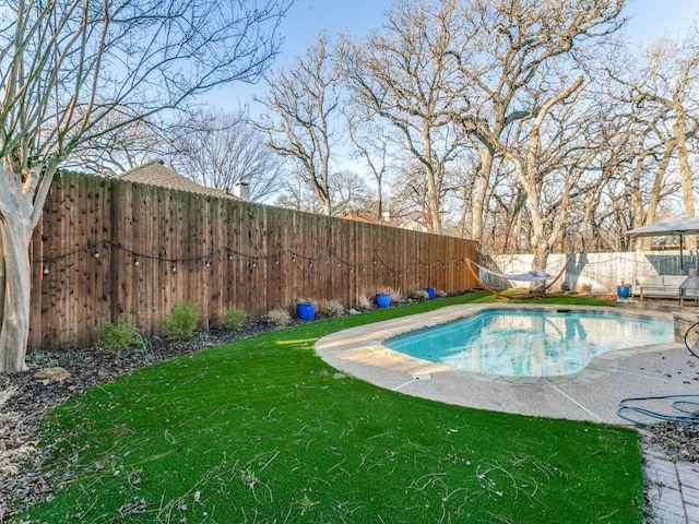 view of swimming pool with a yard, a fenced backyard, and a fenced in pool