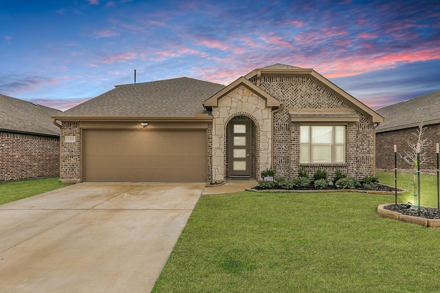 view of front of property with driveway, a garage, stone siding, a front yard, and brick siding