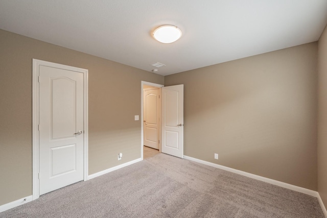 empty room with light carpet and baseboards