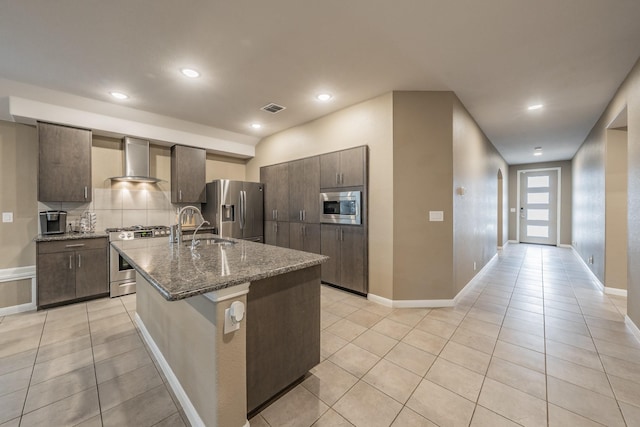 kitchen with visible vents, decorative backsplash, stainless steel appliances, wall chimney range hood, and light tile patterned flooring