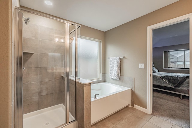 bathroom with a garden tub, baseboards, a shower stall, tile patterned floors, and ensuite bath